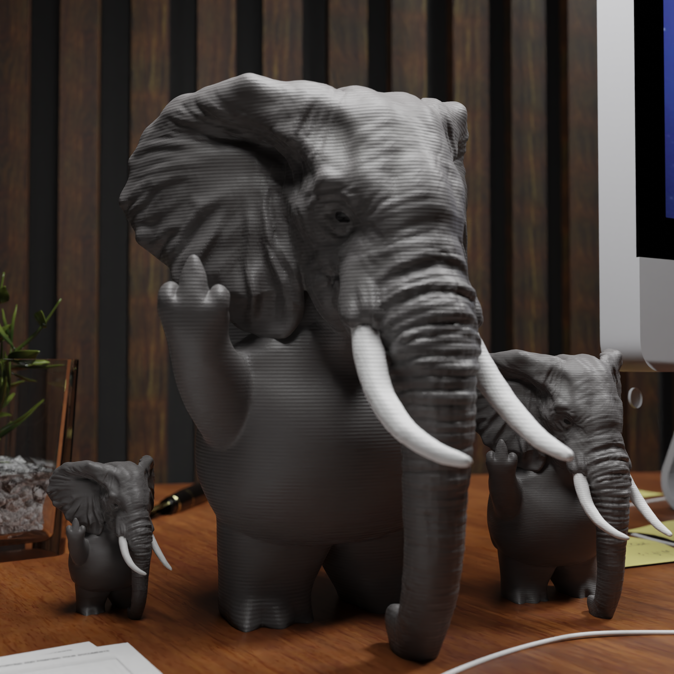 Small elephant figurine placed next to a computer, miniature wild animal decoration and funny elephant gift for office desk workspace