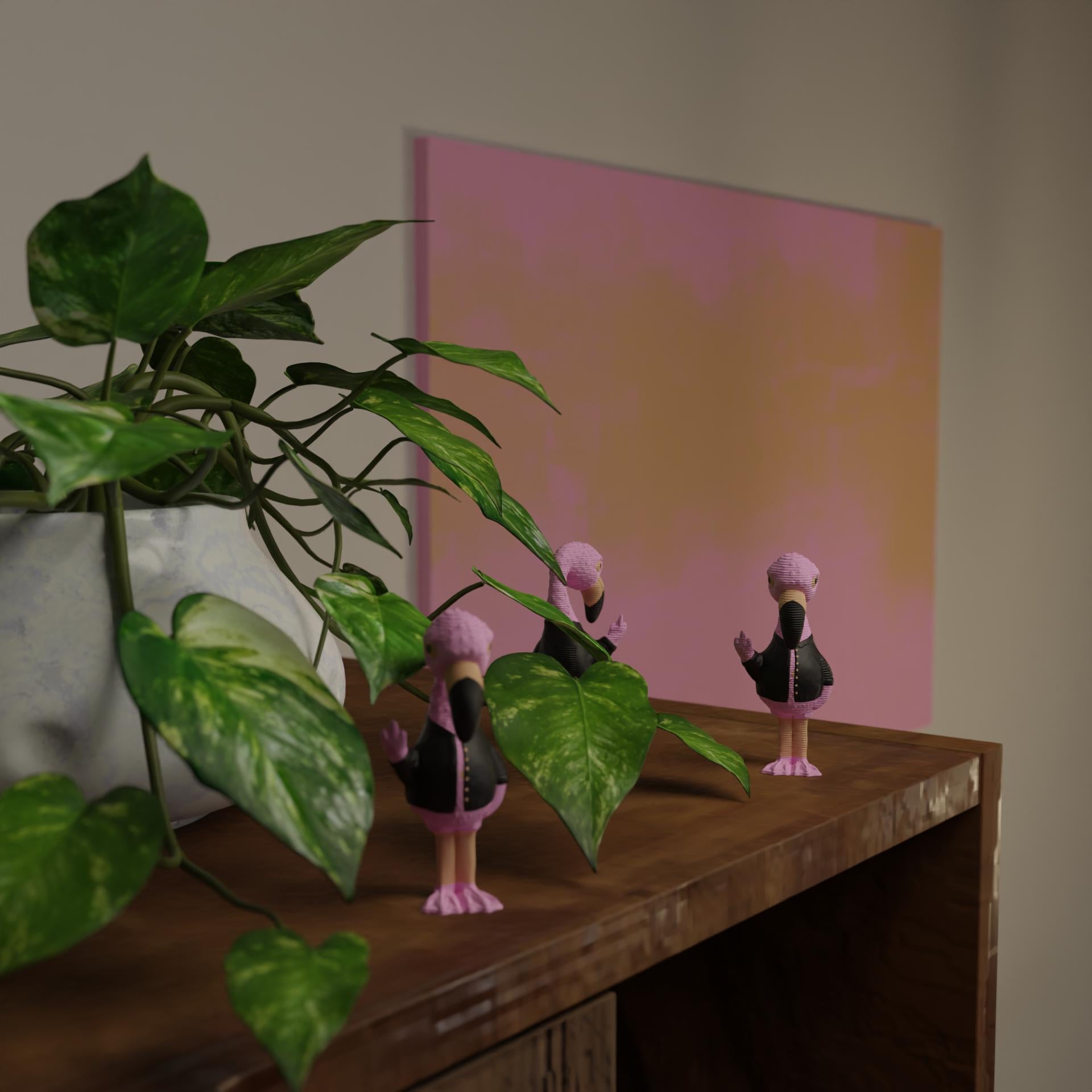Small flamingo figurine next to a plant, funny miniature animal decoration for home decor with greenery